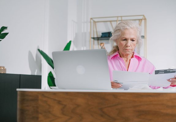 Mujer mayor revisando los documentos para cobrar el seguro de vida de un familiar