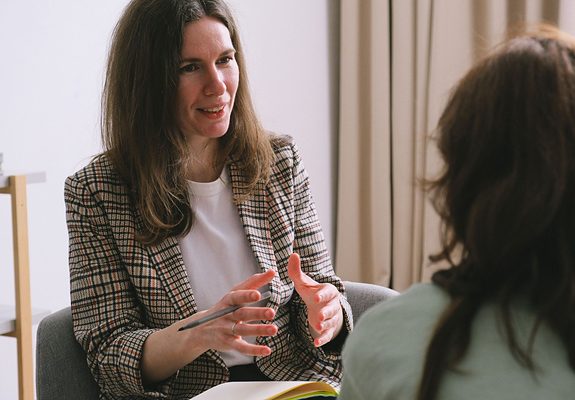 Psicóloga conversando con una paciente durante una sesión de psicoterapia cubierta por el seguro médico ASISA