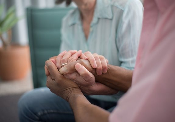 Dos personas cogidas de las manos en un gesto de apoyo tras la pérdida de un familiar