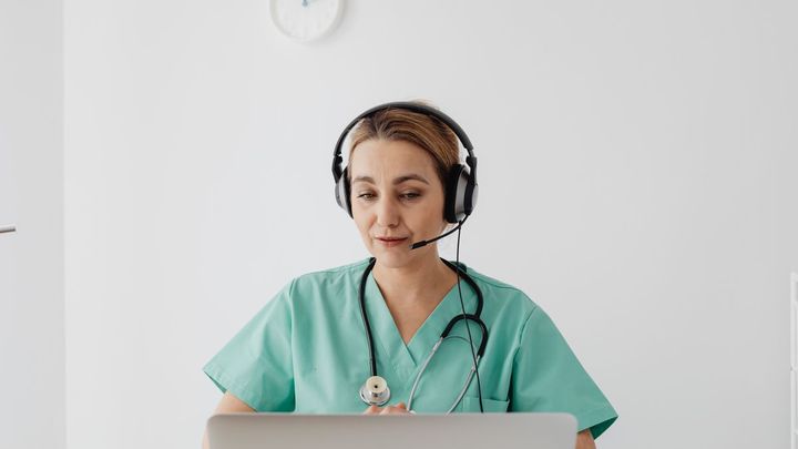 Médica atendiendo una videoconsulta con el portátil