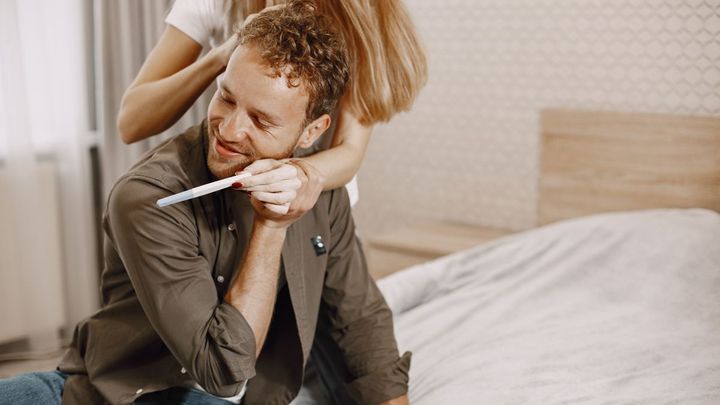 Pareja feliz con un test de embarazo positivo