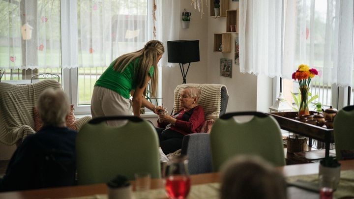 Cuidadora atendiendo a dos mujeres mayores en una residencia
